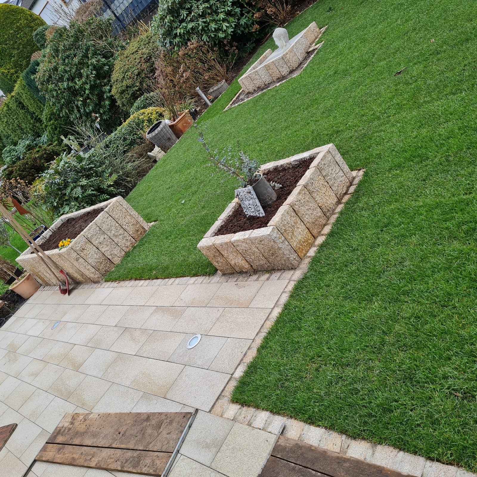 Gartenanlage mit Rasenfläche, Plattenweg und gemauertem Hochbeet