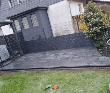 Anthrazitfarbener Sichtschutzzaun an einer neu angelegten Rasenfläche
