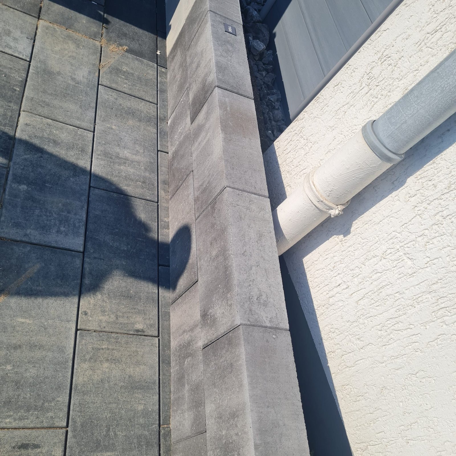 Geschwungene Terrassenfläche mit hellen Platten und dunkler Randeinfassung
